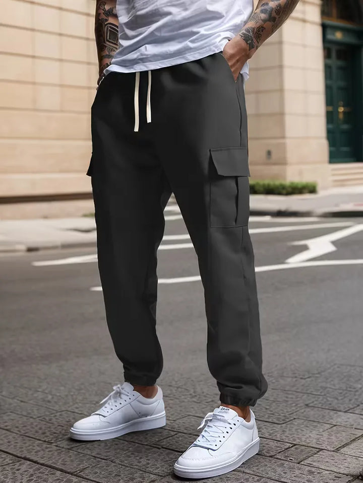 Olijfgroene heren cargo broek, taps toelopend, met klepzakken en trekkoord. Comfortabele streetwear.