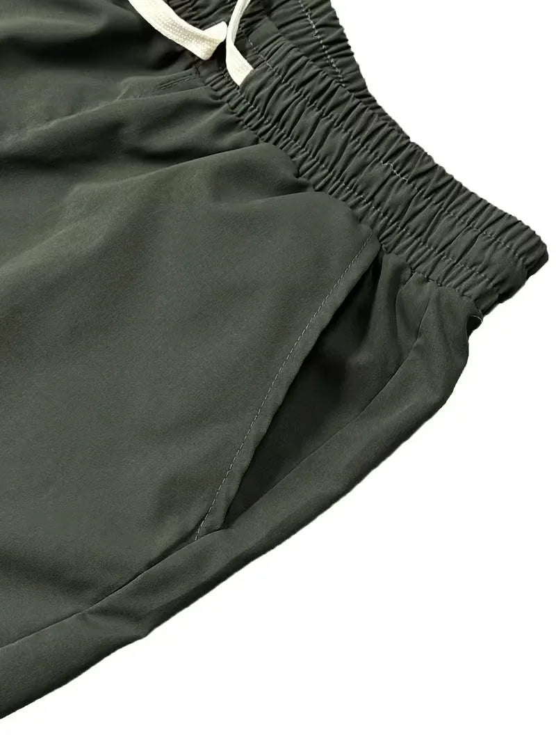 Model draagt olijfgroene taps toelopende heren cargo broek met klepzakken. Perfect voor streetwear stijl.