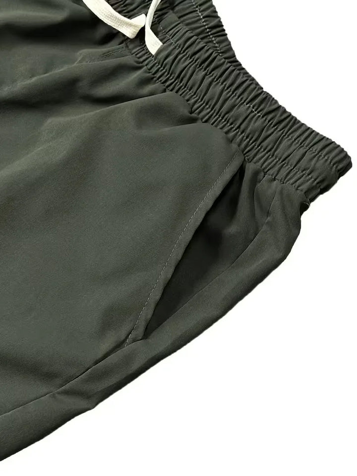 Model draagt olijfgroene taps toelopende heren cargo broek met klepzakken. Perfect voor streetwear stijl.