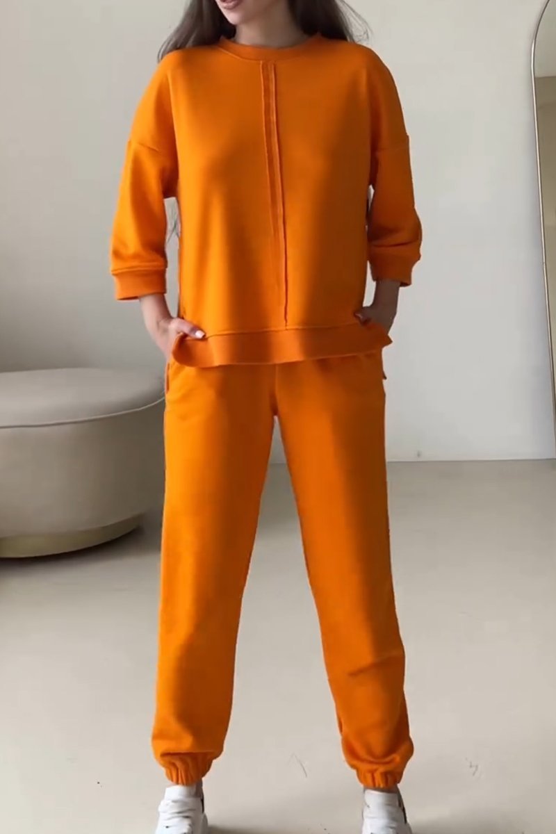 Tweedelige abrikoos dames outfit: oversized trui en bijpassende joggingbroek voor een stijlvolle en comfortabele loungewear set.
