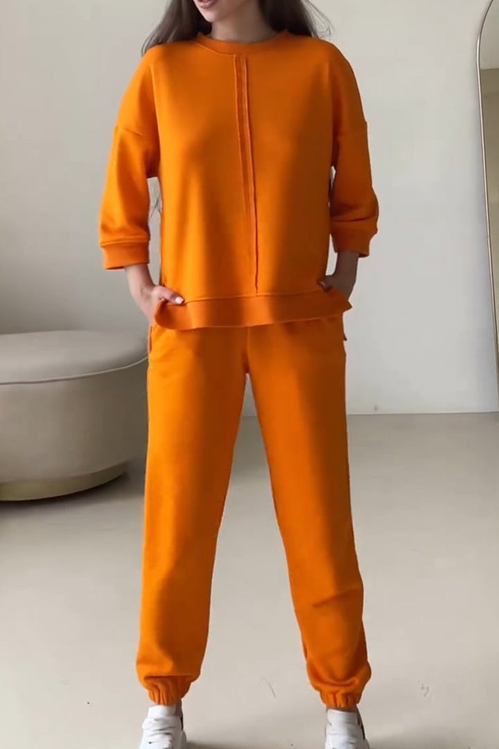 Tweedelige abrikoos dames outfit: oversized trui en bijpassende joggingbroek voor een stijlvolle en comfortabele loungewear set.
