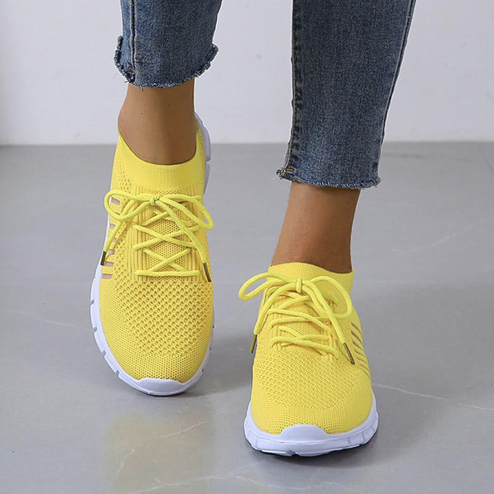 Close-up van de vetersluiting van een groene orthopedische sneaker, voor een verstelbare en comfortabele pasvorm.
