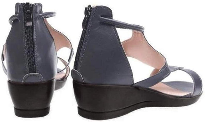 Orthopedische damessandaal met verhoogde hak en verstelbaar enkelbandje, elegant design in zwart leer.