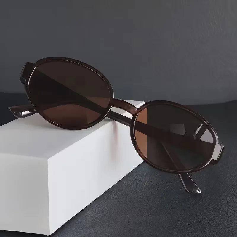 Veelzijdige unisex ovale zonnebril, lichtgewicht met donkere glazen, past bij elke casual outfit.