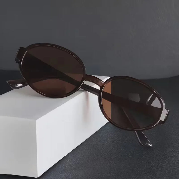 Veelzijdige unisex ovale zonnebril, lichtgewicht met donkere glazen, past bij elke casual outfit.