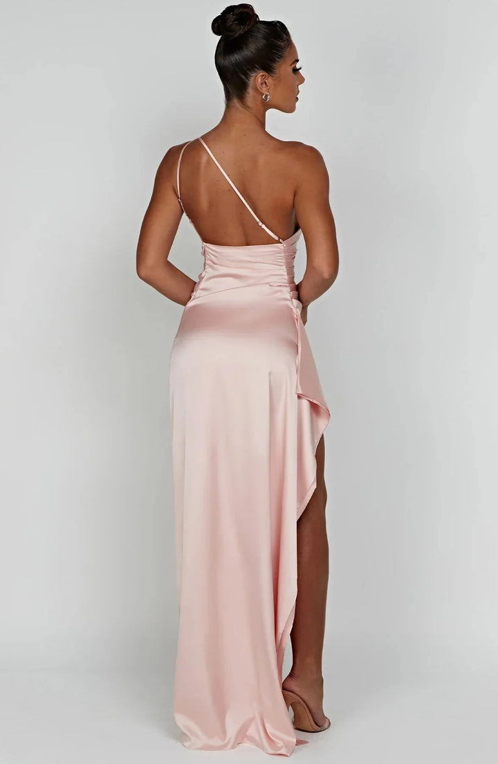 Beige maxi feestjurk met één blote schouder, tailleplooien en verleidelijke zijsplit.