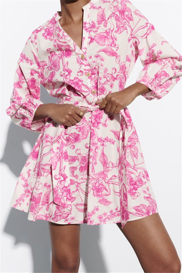 Roze gebloemde korte damesjurk met wijde mouwen en verstelbare taille. Perfecte elegante zomerjurk voor dagelijks gebruik.