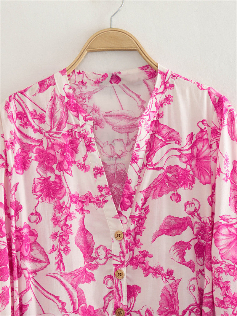 Vrouwelijke korte damesjurk met roze bloemenprint, wijde mouwen en verstelbare taille. Ideale gebloemde dagjurk.