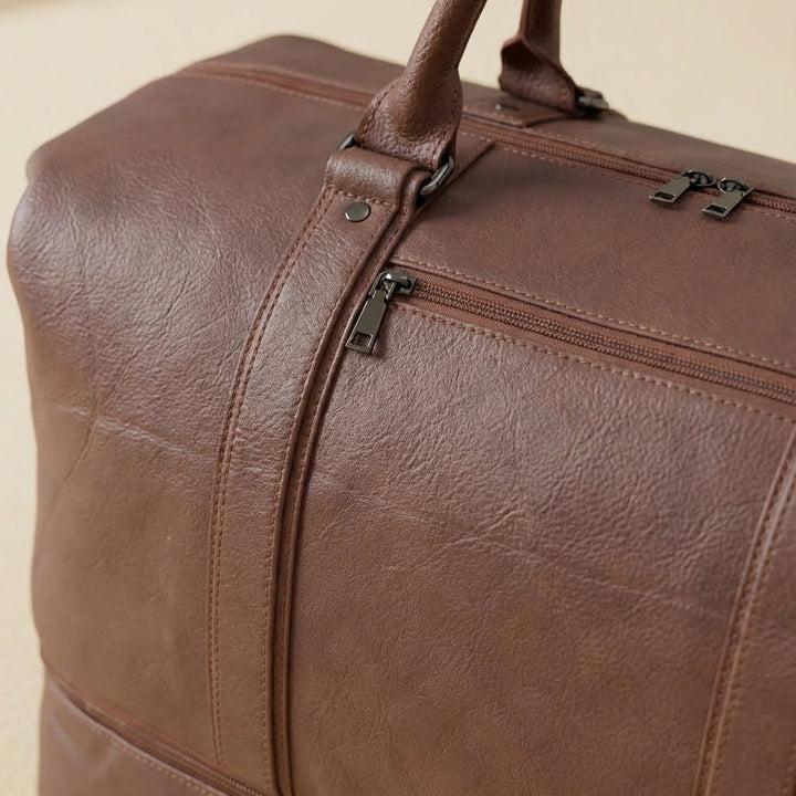 Duurzame leren reisbagage, een ruime weekendtas met stevige draagtas functies voor lange reizen.