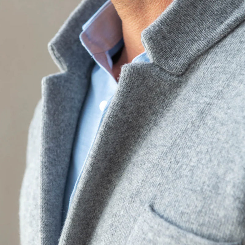 Detailopname van de gebreide textuur van het heren colbert met revers en knopen, geschikt voor zowel zakelijk als casual.