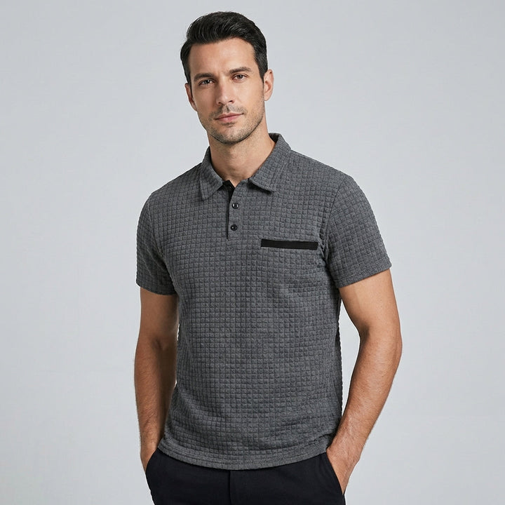 Man draagt een zwart slim-fit poloshirt, toont de slanke pasvorm en moderne mannenmode.