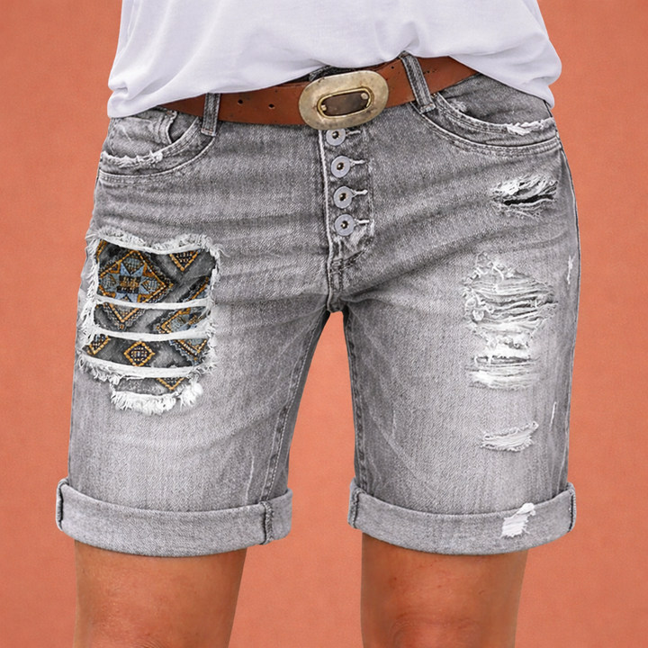 Stijlvolle dames denim shorts met trendy ripped details, perfect voor een casual zomerlook in blauw of grijs.