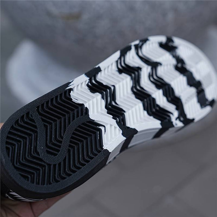 Dynamische foto van heren skateschoenen in actie, toont de flexibiliteit en grip tijdens een skateboardtrick.