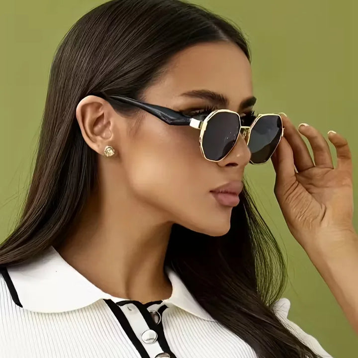 Close-up van trendy unisex ronde zonnebril met glanzend goud frame en donkere anti-schittering glazen.