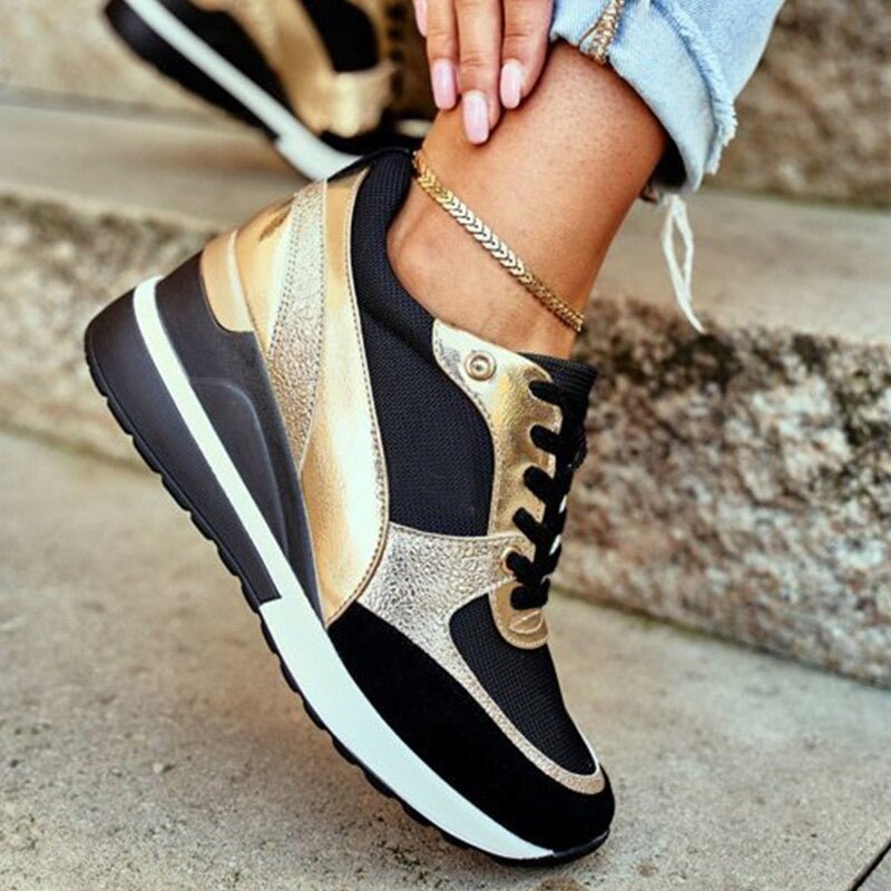Stijlvolle zwarte dames sneakers met comfortabele pasvorm en elegante gouden accenten, ideaal voor dagelijks gebruik.