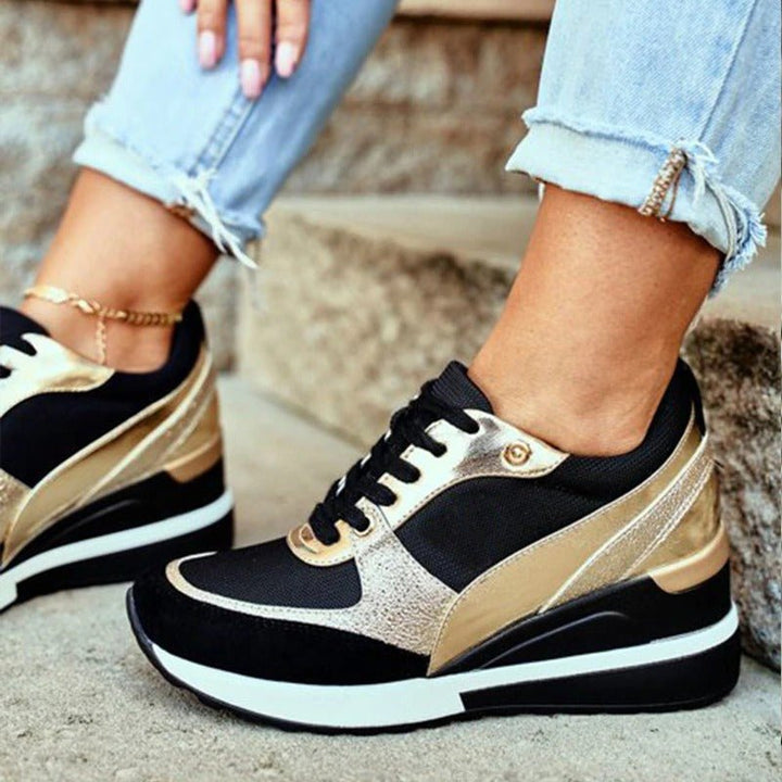 Comfortabele dames sneakers in zwart met luxe gouden accenten, bieden zowel stijl als gemak voor elke gelegenheid.