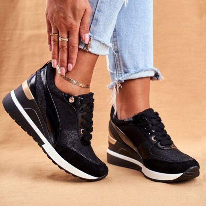 Trendy zwarte dames sneakers met opvallende gouden details, combineren modieus design met optimaal comfort voor vrijetijd.