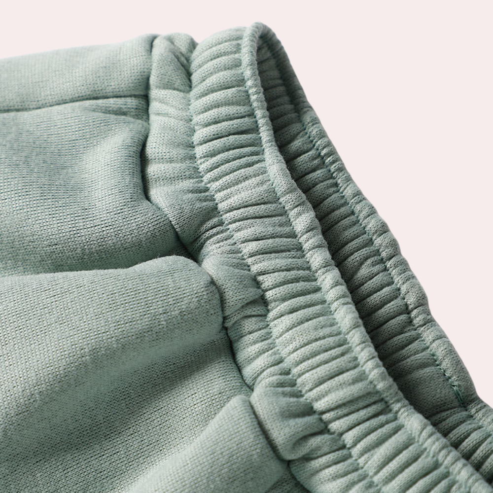 "Tweedelig dames joggingpak in groen, comfortabel met halve-rits vest en modieuze jogger, ideaal voor elke gelegenheid."