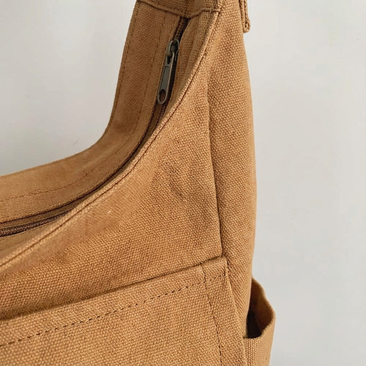 Man draagt canvas crossbody tas: Comfortabele unisex schoudertas, ideaal voor reizen en dagelijkse pendel.