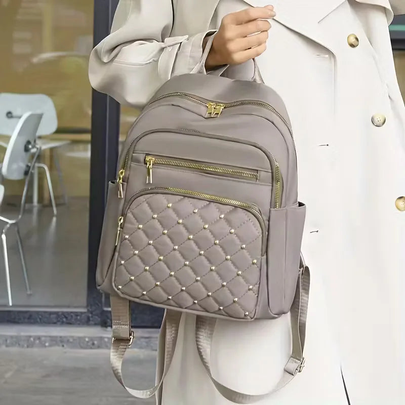 Model draagt stijlvolle unisex rugzak met studs; een veelzijdig en casual mode-item voor elk seizoen.
