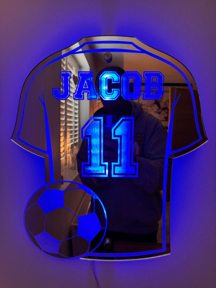Decoratieve GoalGleam spiegel in voetbalshirt vorm. Ideaal geschenk voor sportfans en als unieke wanddecoratie.