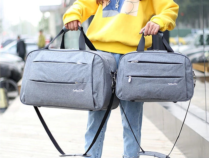 Unisex handbagage reistas met trolleybevestiging voor vliegreizen, compact en zwart.