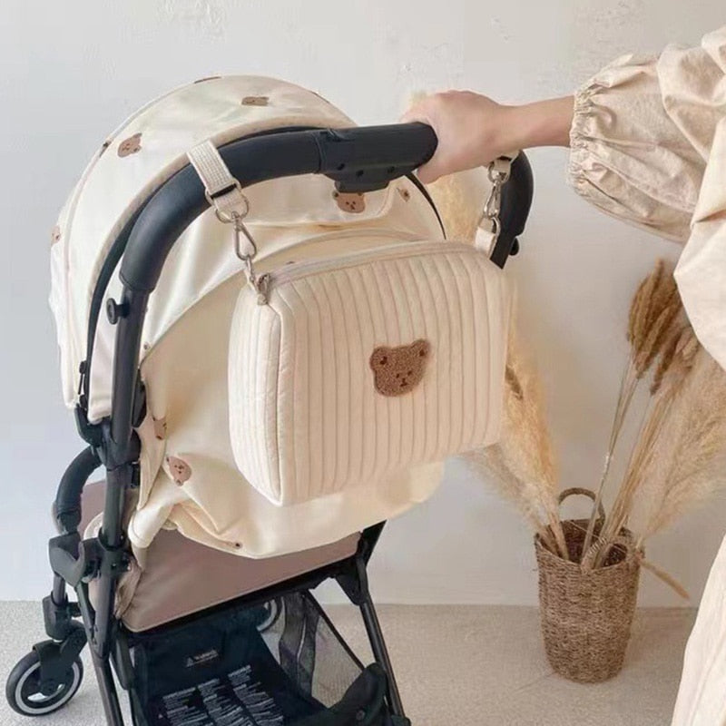 Open unisex luiertas met schattige beer, toont georganiseerde compartimenten voor alle babyverzorging items.