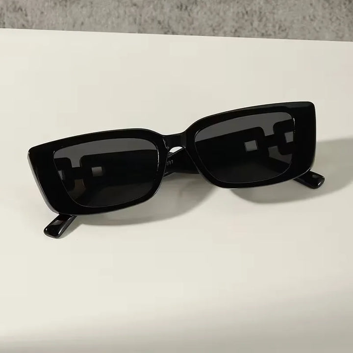 Stijlvolle zwarte rechthoekige zonnebril, unisex design. Perfect accessoire met UV-bescherming voor een elegante uitstraling.