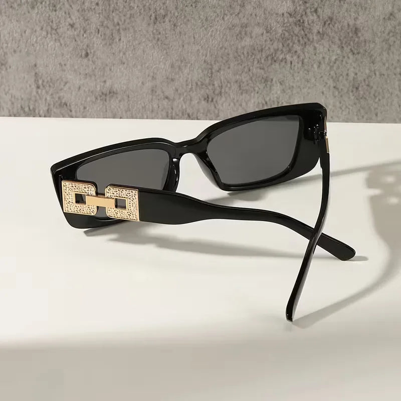 Rechthoekige unisex zonnebril, zwart polycarbonaat frame. Biedt optimale UV-bescherming en een modieuze, elegante look.