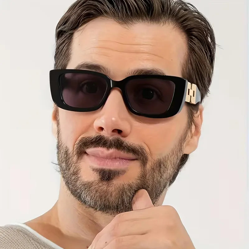 Elegante unisex zonnebril met rechthoekig zwart frame. Een modieus accessoire dat UV-bescherming biedt.