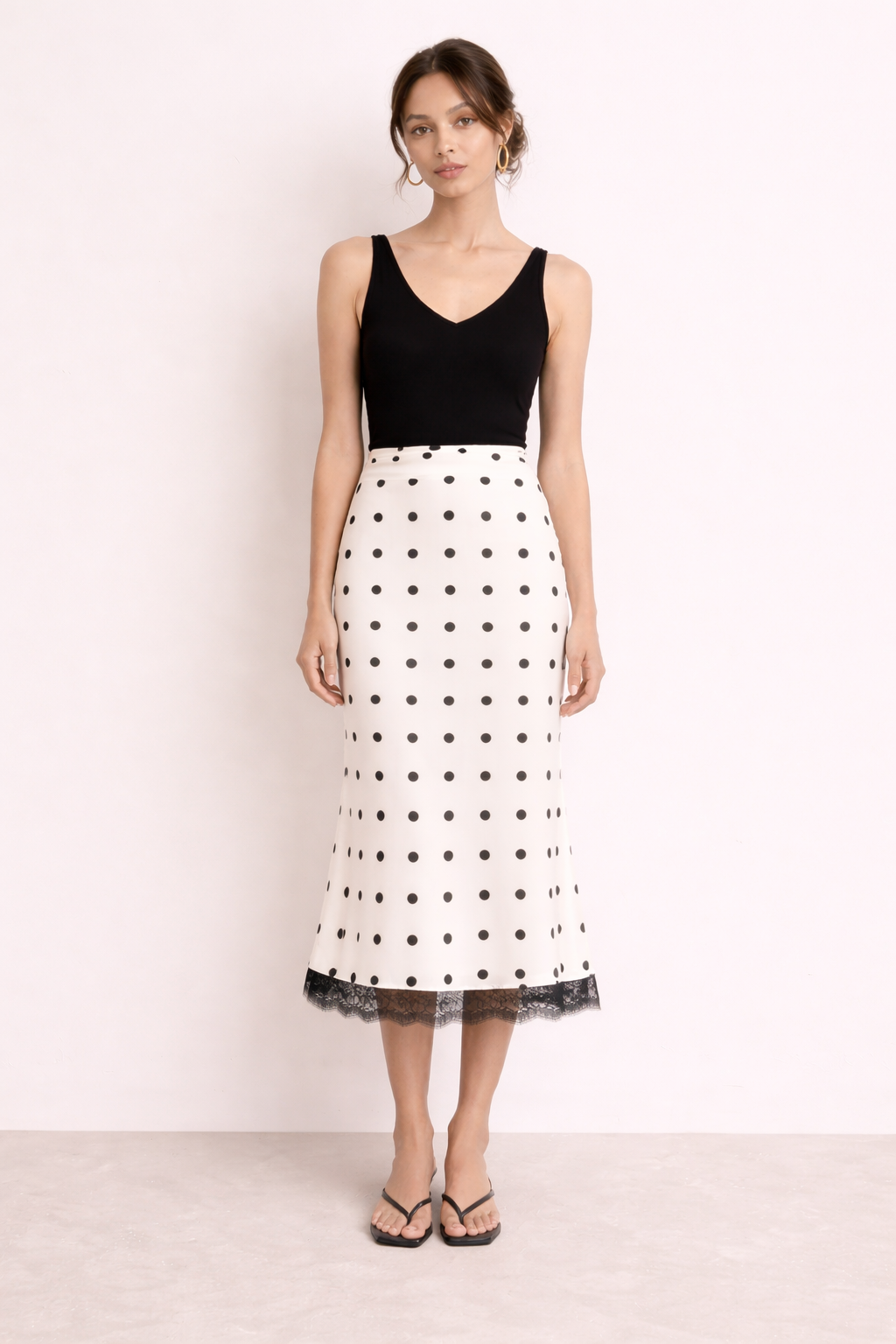 Comfortabele midi-rok met witte stippenprint en chique kanten zoom. Geschikt voor dames, vrouwelijk en luchtig.