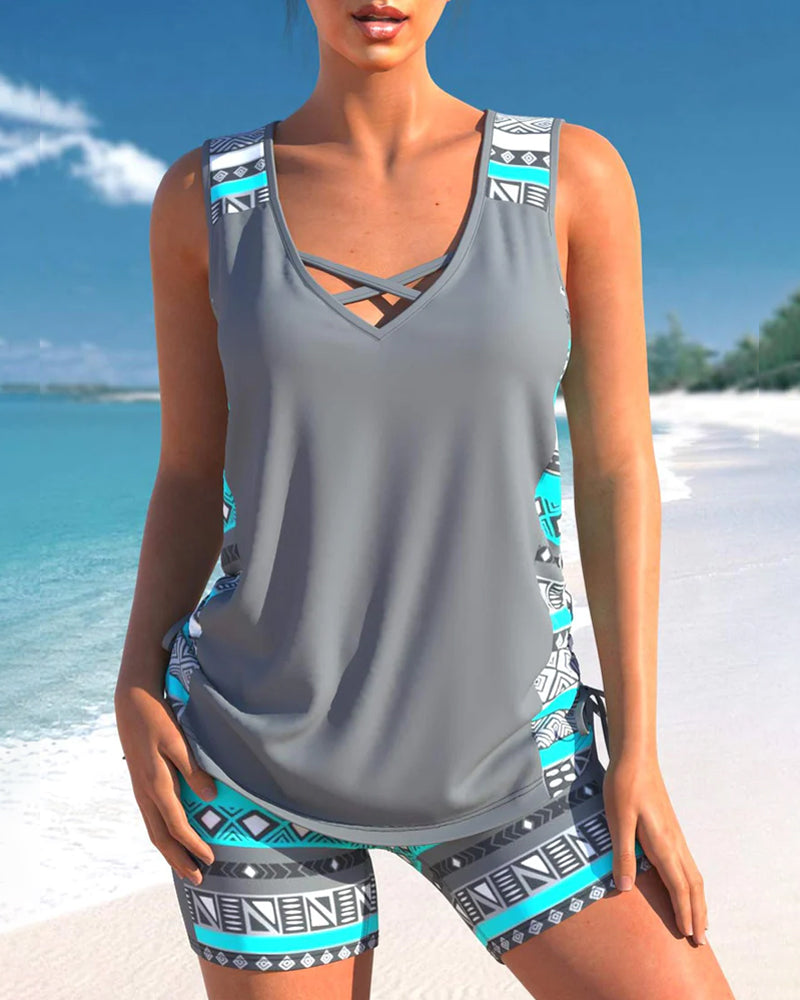 Vrouwen dragen een blauw/wit gestreepte tankini, lachend op het strand. Perfect voor zomer strandmode.