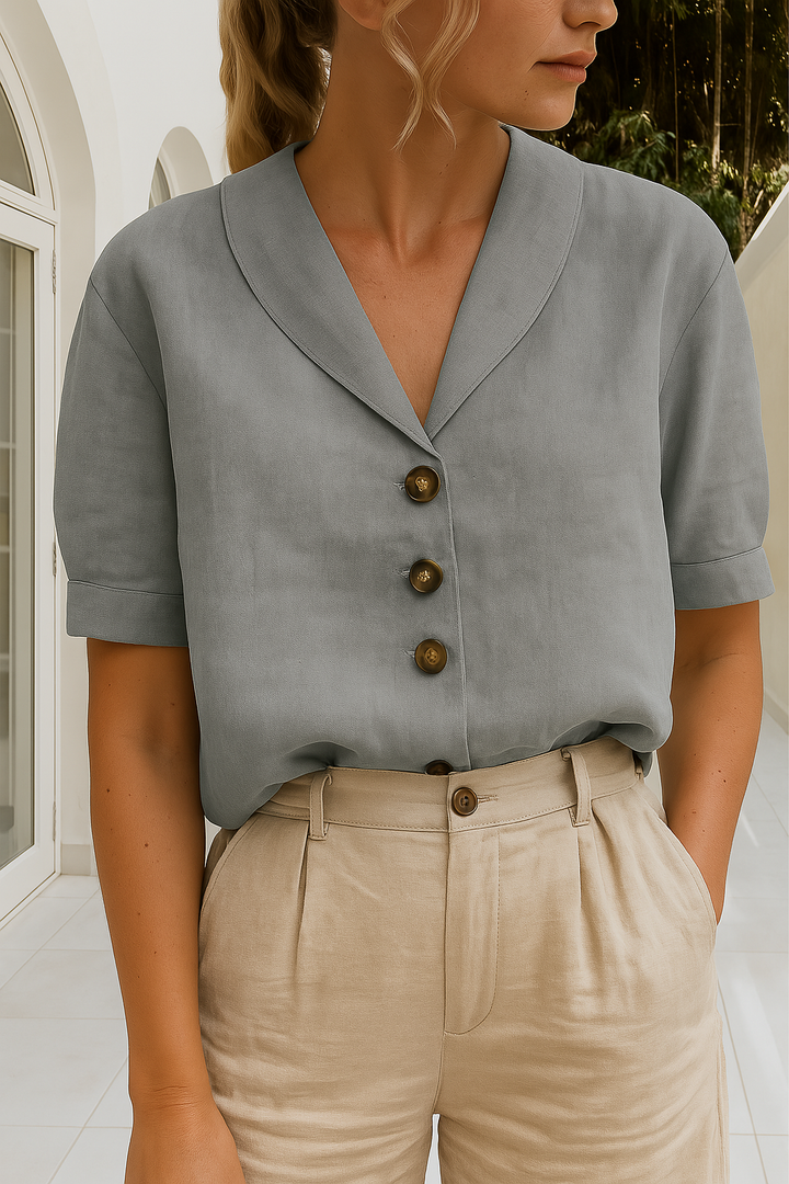 Elegante dames top met verfijnde envelophals en unieke knoopdetails op de schouder. Tijdloos en stijlvol.