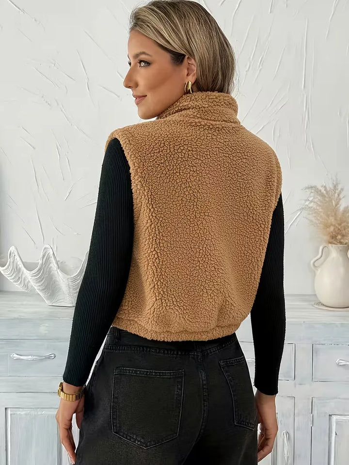 Comfortabel dames vest in bruin faux shearling, met rits voor makkelijk aan- en uittrekken.