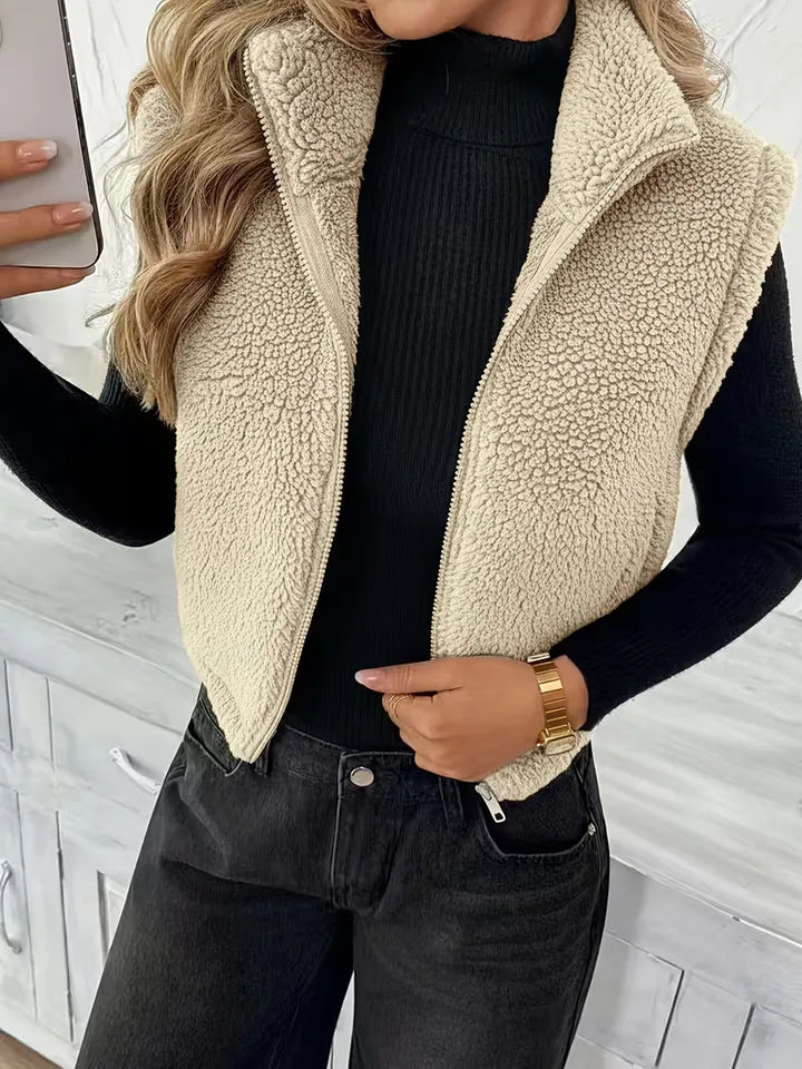 Stijlvol zwart mouwloos dames vest van faux shearling met praktische rits.