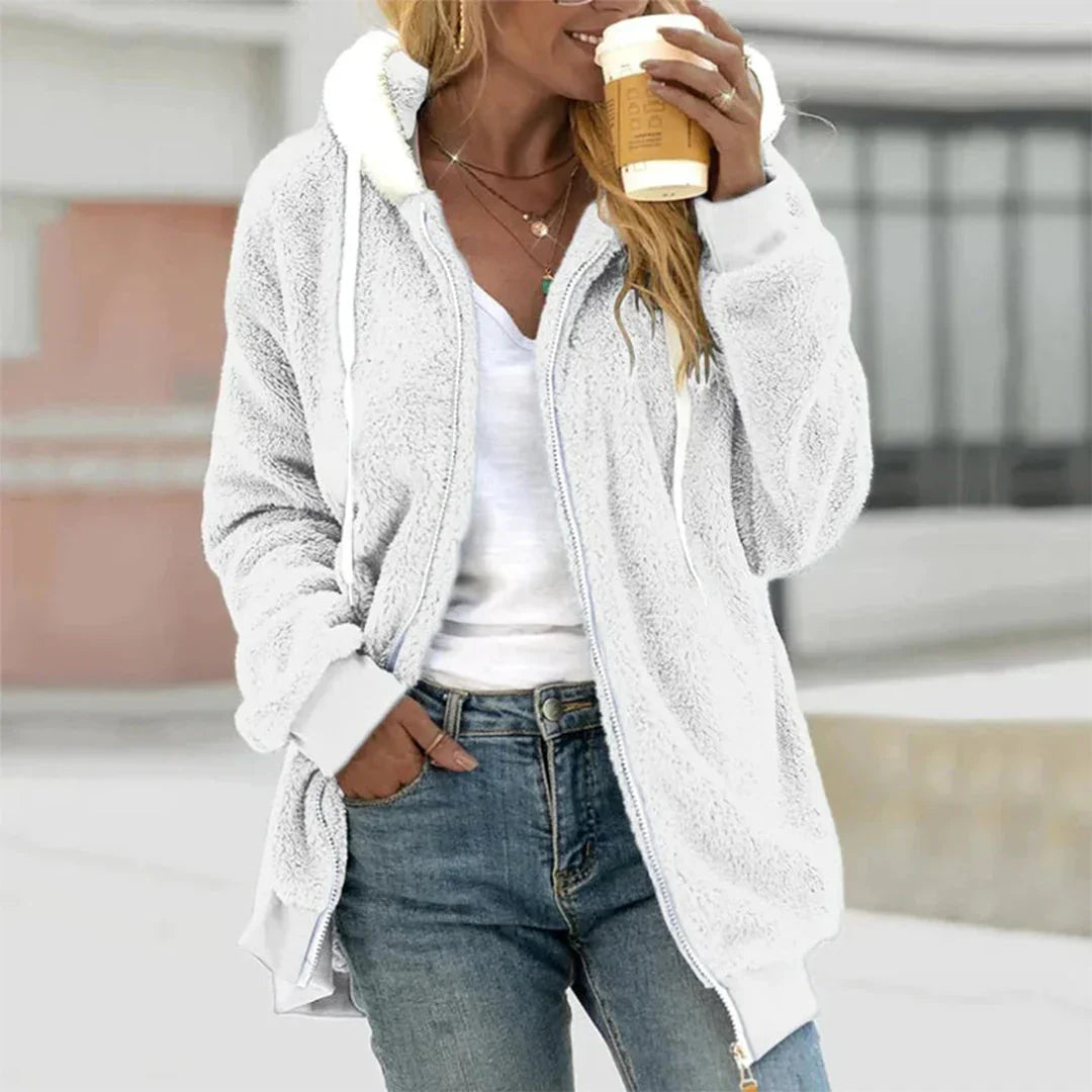 Model draagt een warm, losvallend Hoymans dames pluche vest met capuchon in winterse setting.