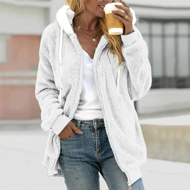 Model draagt een warm, losvallend Hoymans dames pluche vest met capuchon in winterse setting.