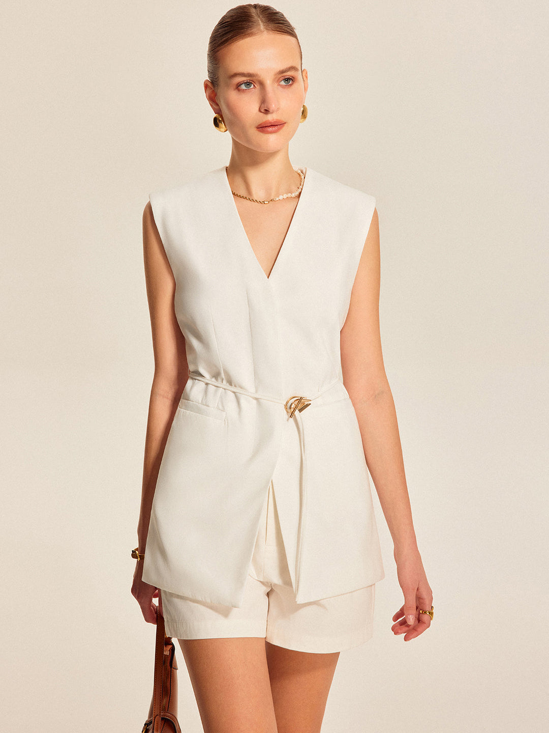 Wit damesvest met V-hals en ceintuur, ideaal voor een elegante laagjeslook.