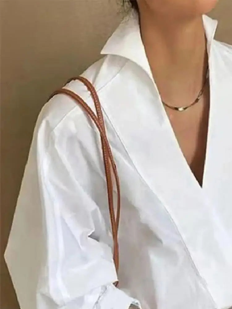 "Witte damesblouse met V-hals en pofmouwen, gemaakt van katoenmengsel. Casual ontwerp, ideaal voor lente en zomer."