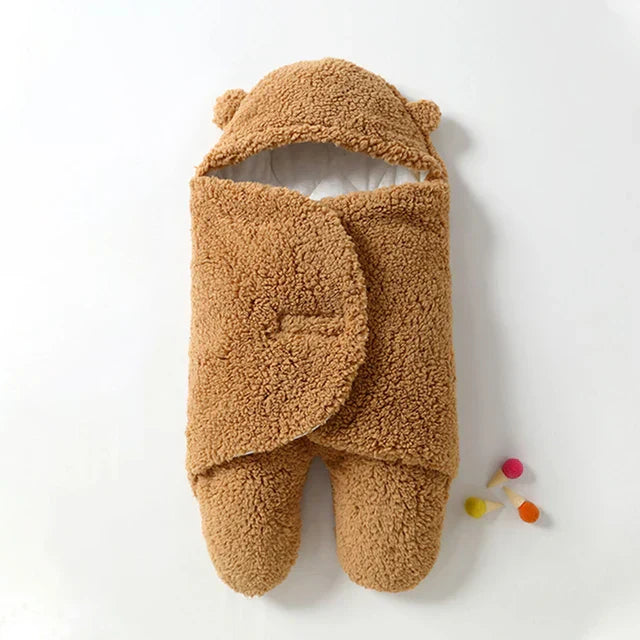 Ademende wikkeldeken van katoen; biedt baby warmte en geborgenheid.