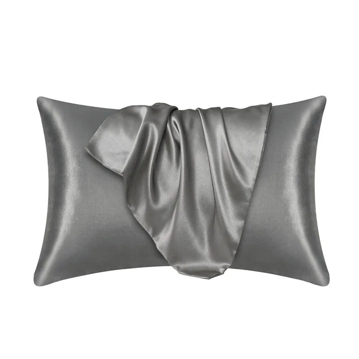 Crèmekleurige polyester kussensloop op bed, benadrukt huidvriendelijk en haarvriendelijk materiaal.