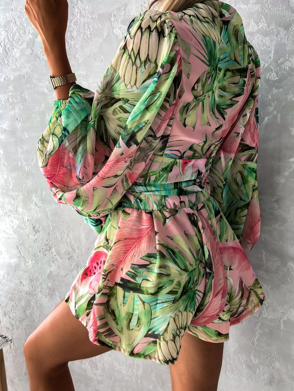 "Zomerse playsuit met V-hals, fruit- en bladmotieven, kleurrijke tropische print, accentueert silhouet en biedt comfort."