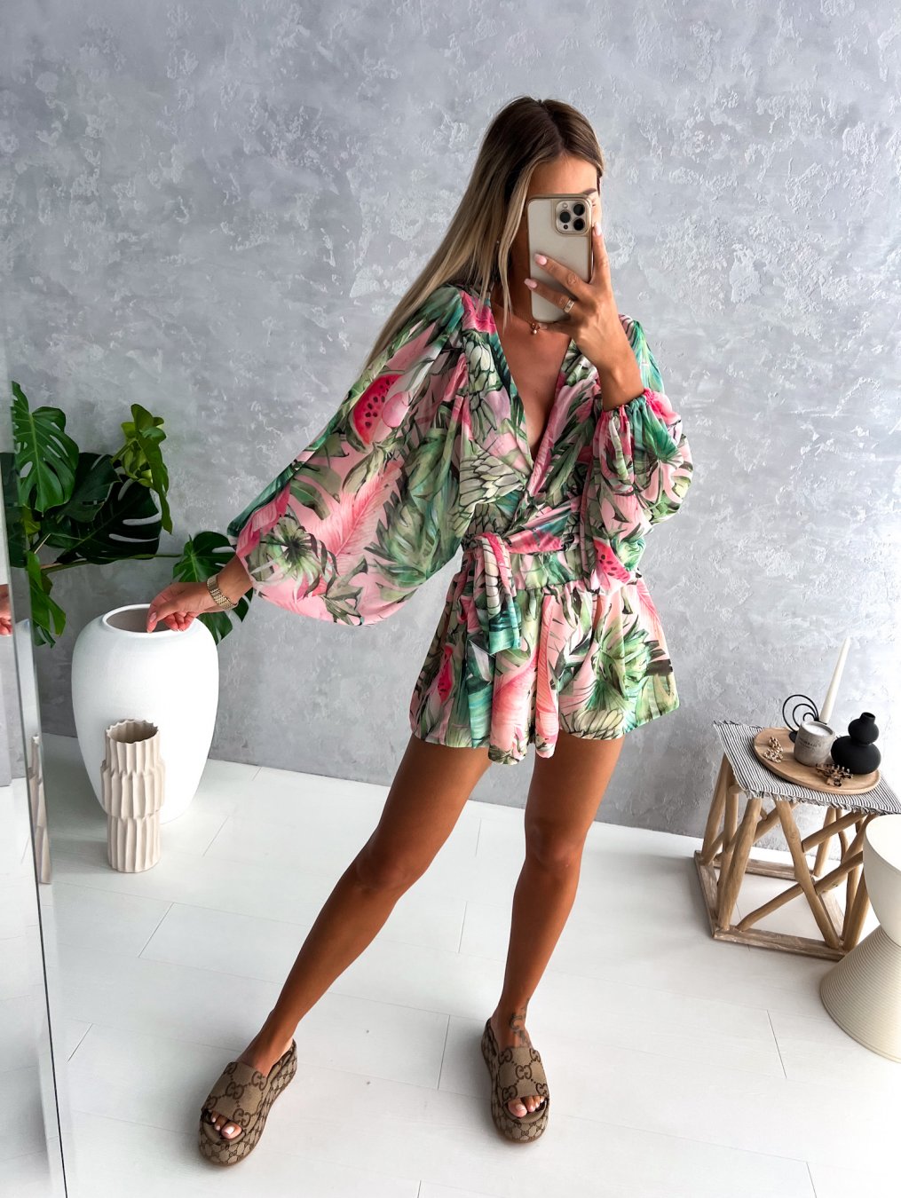 "Zomerse playsuit met V-hals, fruit- en bladmotieven, kleurrijke tropische print, accentueert silhouet en biedt comfort."