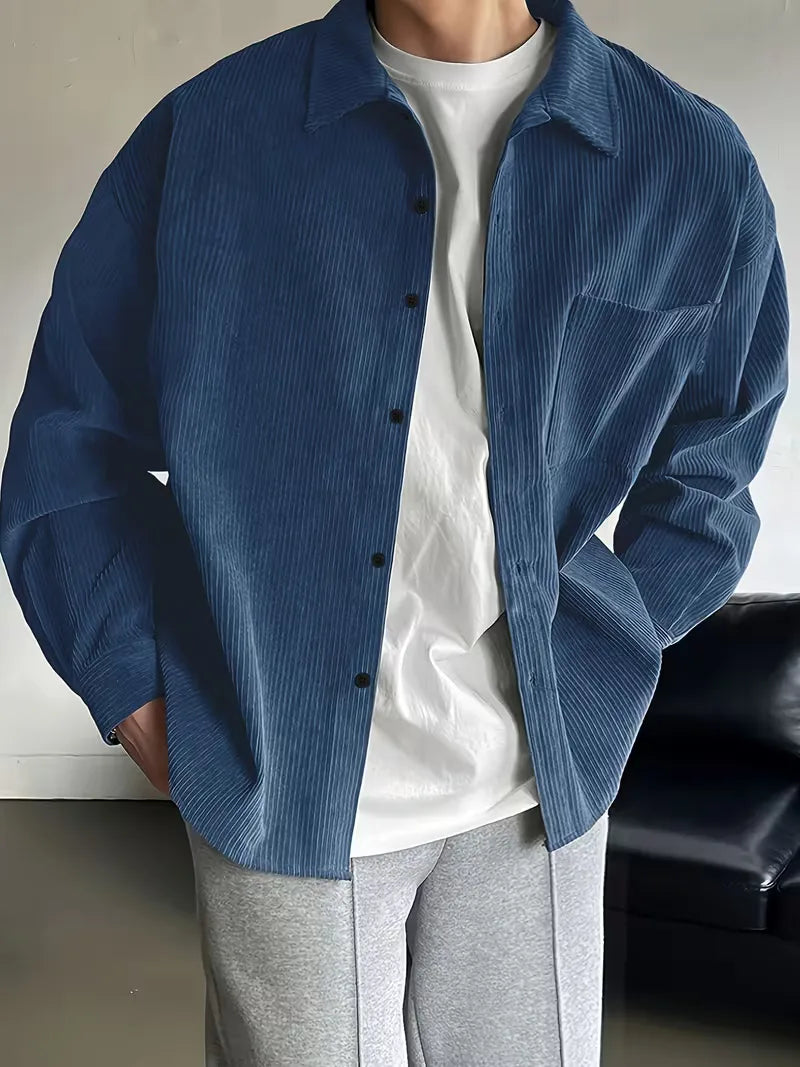 Donkergroen herenoverhemd, ribstructuur, model draagt het met casual broek.