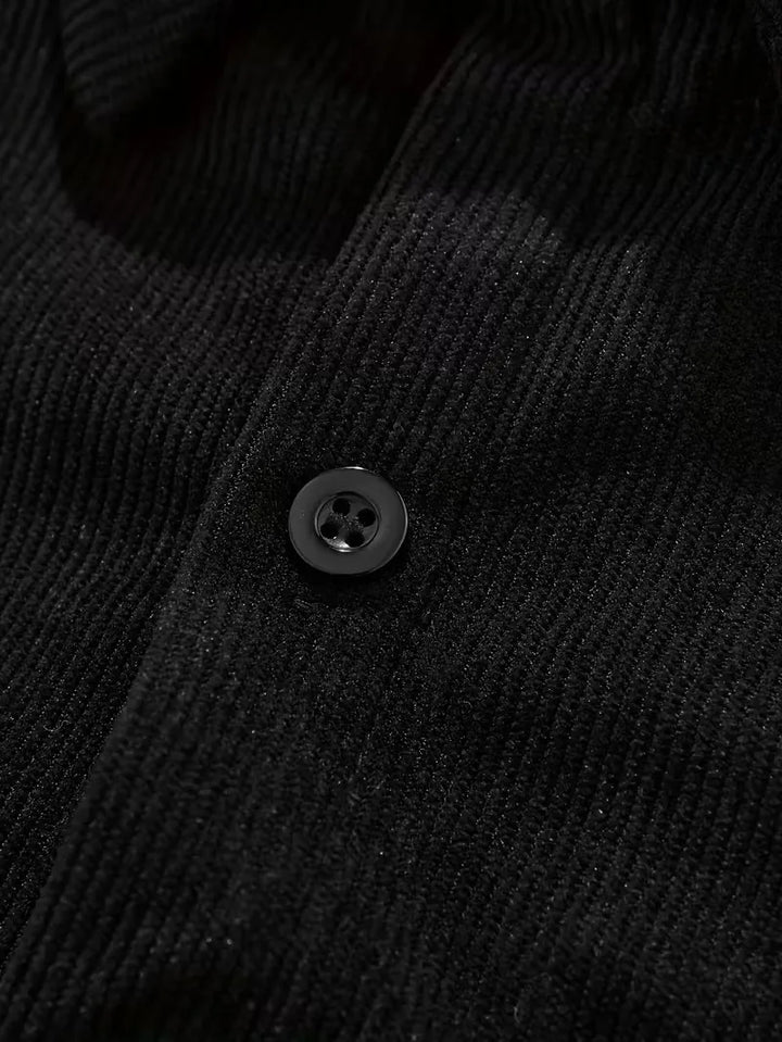 Close-up van de ribstructuur op een zwart casual herenoverhemd.