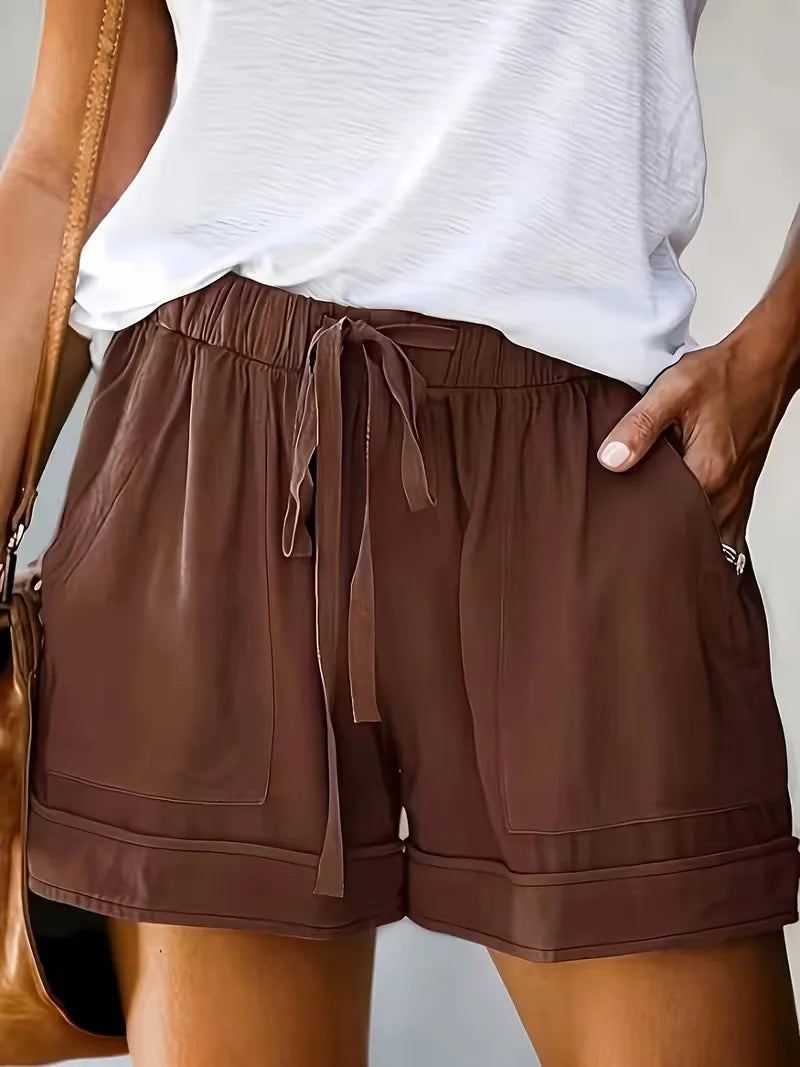 Koraalkleurige dames shorts, relaxte pasvorm. Modieus en comfortabel voor de zomer.