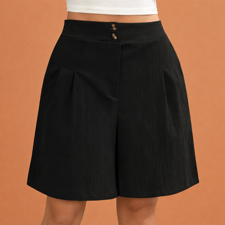 Detail van de stof en plooien van een elegante hoge taille dames shorts. Comfortabel en modern design.
