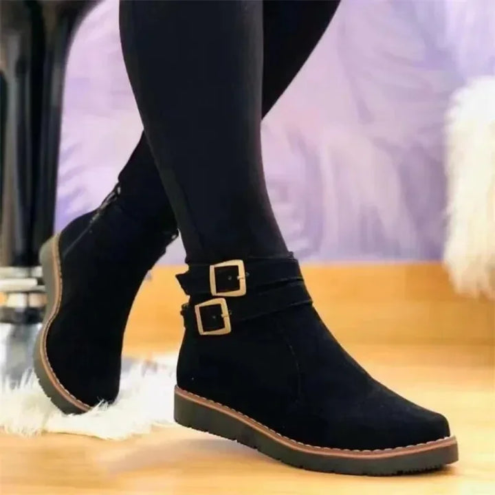 Een vrouw draagt veelzijdige zwarte dames laarzen, perfect voor een stijlvolle herfst- of winteroutfit. (114 chars)