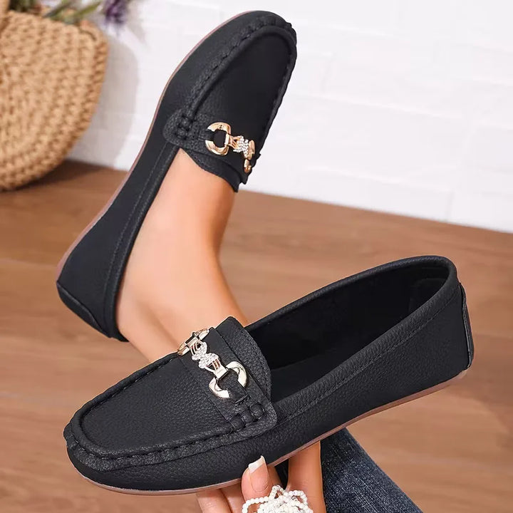 Zwarte elegante dames loafers met stijlvol vlinderdetail. Comfortabele platte instappers voor elke gelegenheid.