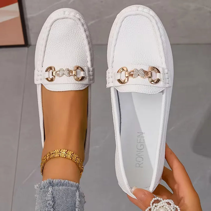 Veelzijdige zwarte dames loafers met chic vlinderdetail. Comfortabele platte instappers, perfect voor een elegante look.